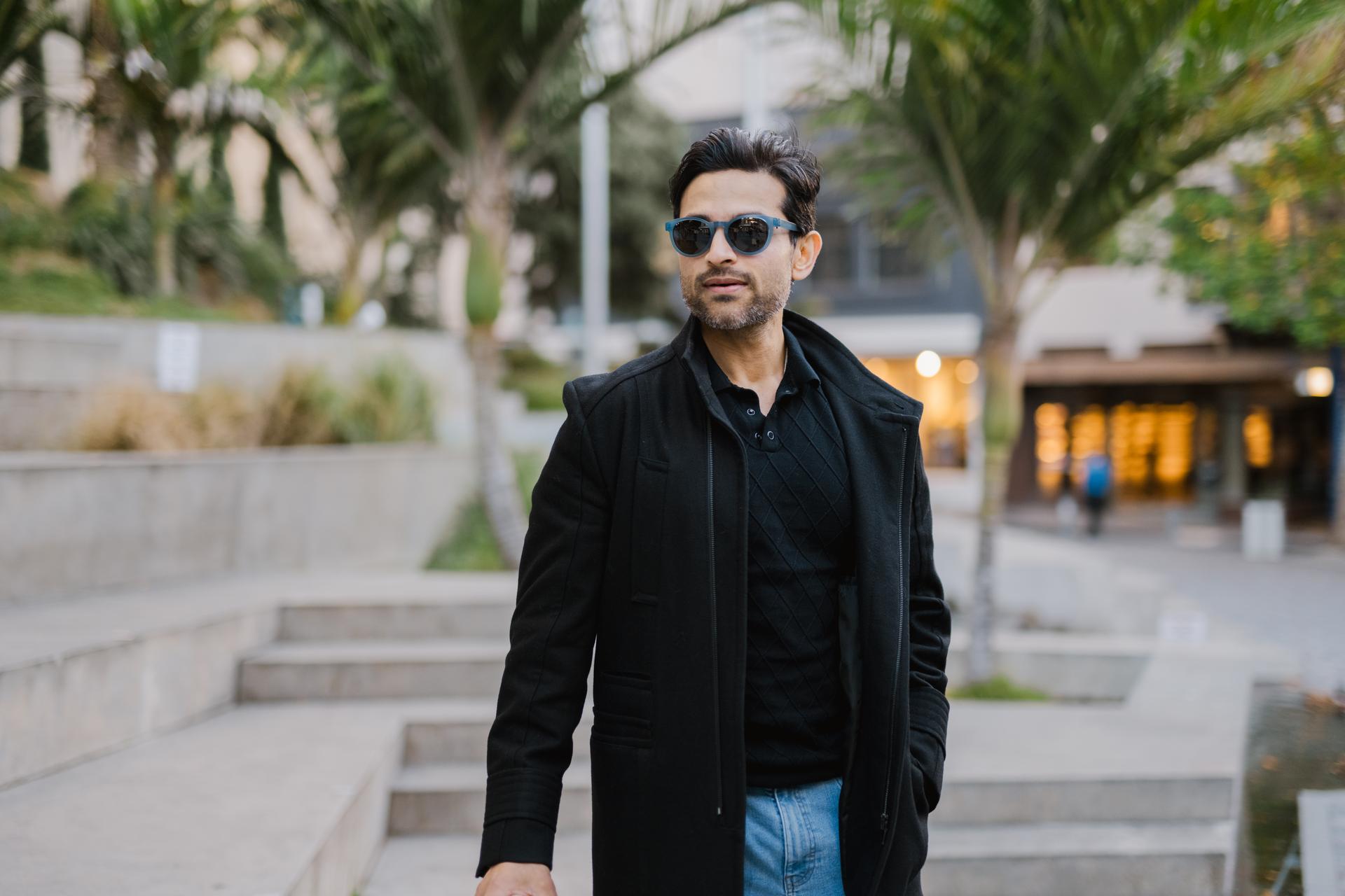 Confident man wearing sunglasses in the city, Dresden Vision United States eyewear balancing fashion and function.