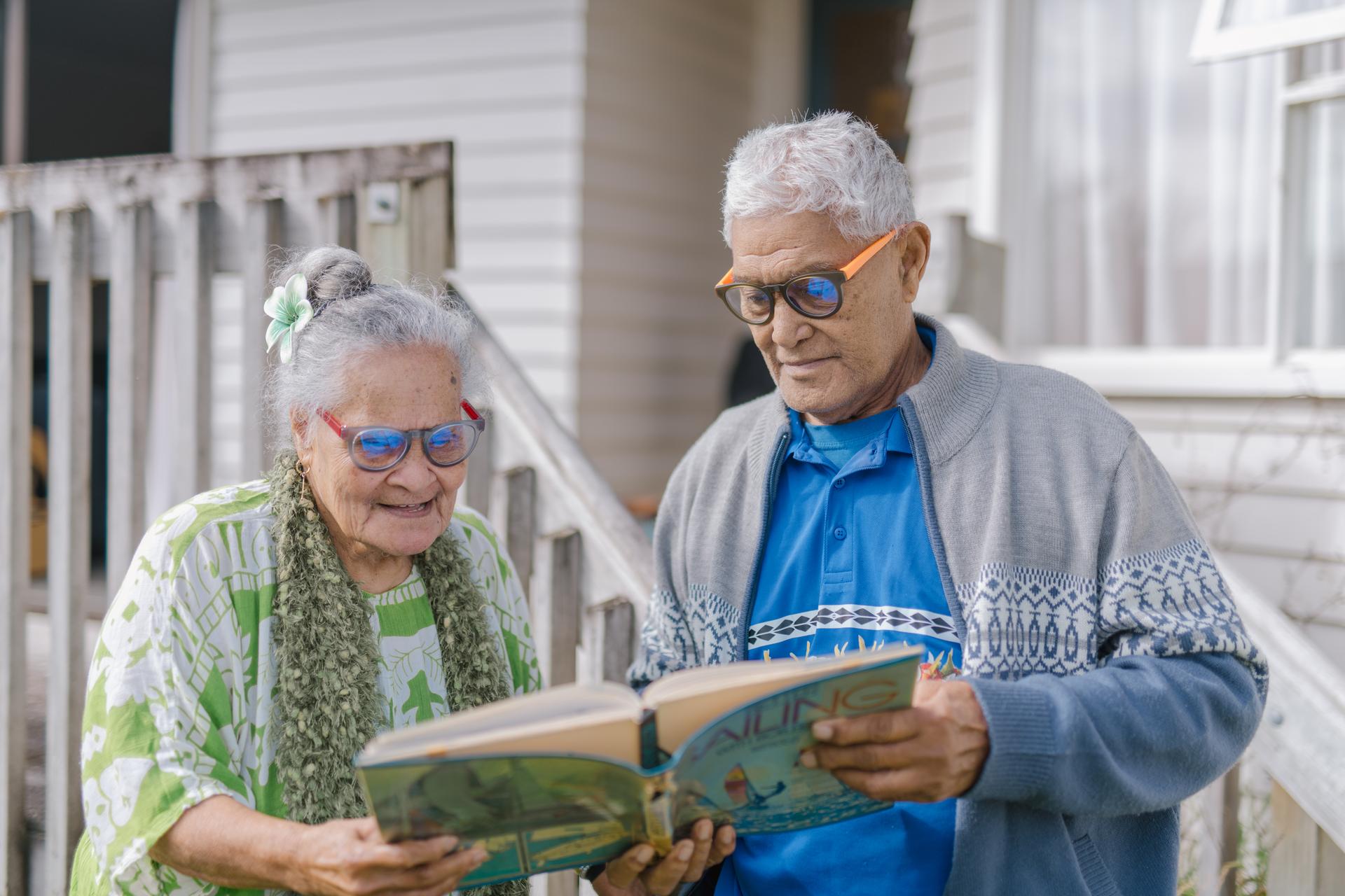 Elderly couple outdoors wearing Dresden Vision Australia multifocal lenses, reading together with clear near and distance vision support.