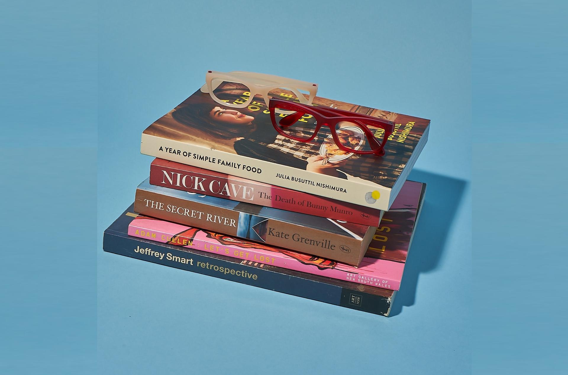 Elevate your study game with stylish glasses and a stack of inspiring books.