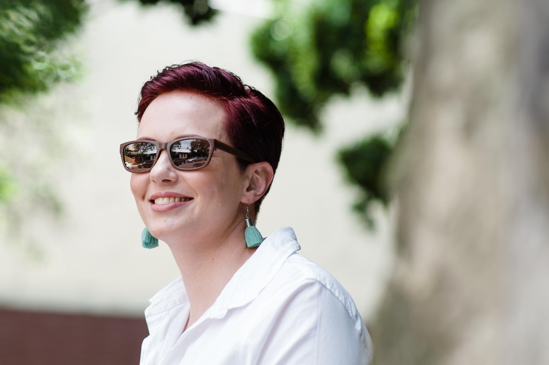 Fashion-forward woman in Dresden Vision United States UV protection prescription glasses, radiating positivity while outdoors in natural light.