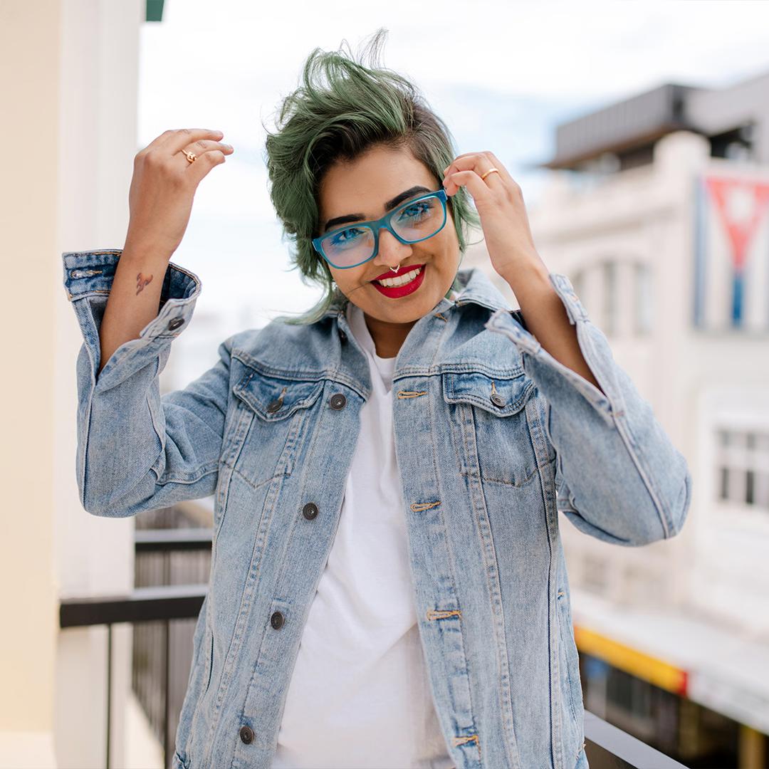 A stylish woman wearing vibrant blue Dresden Vision Australia frames, demonstrating how color and design can make lightweight prescription glasses a comfortable, fashionable statement.