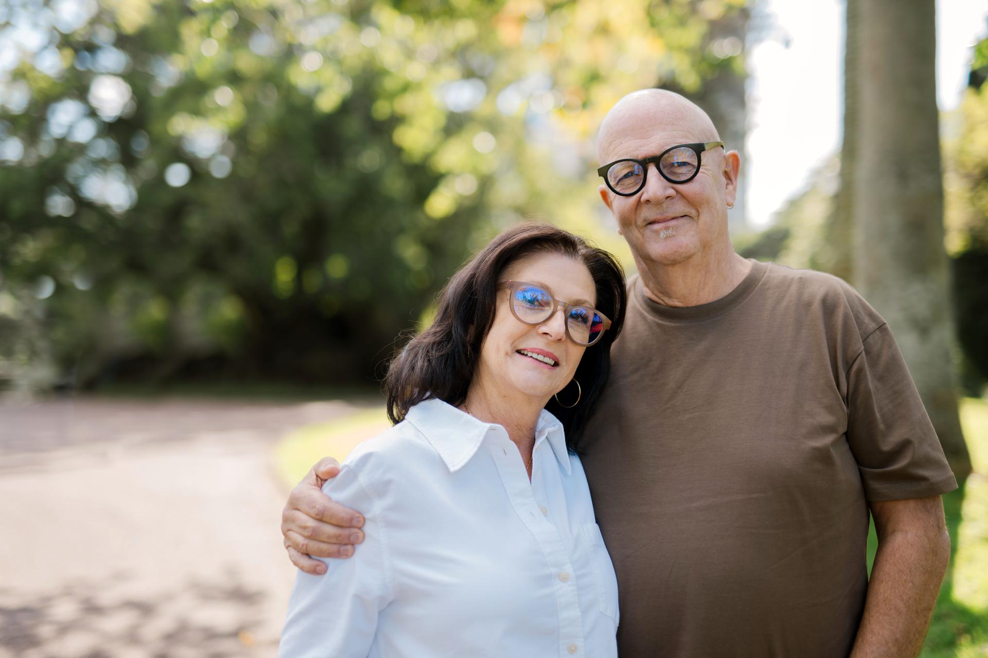 Dresden Vision Canada spring eyewear frames in tan and black worn by a smiling couple in bright, natural outdoor light.