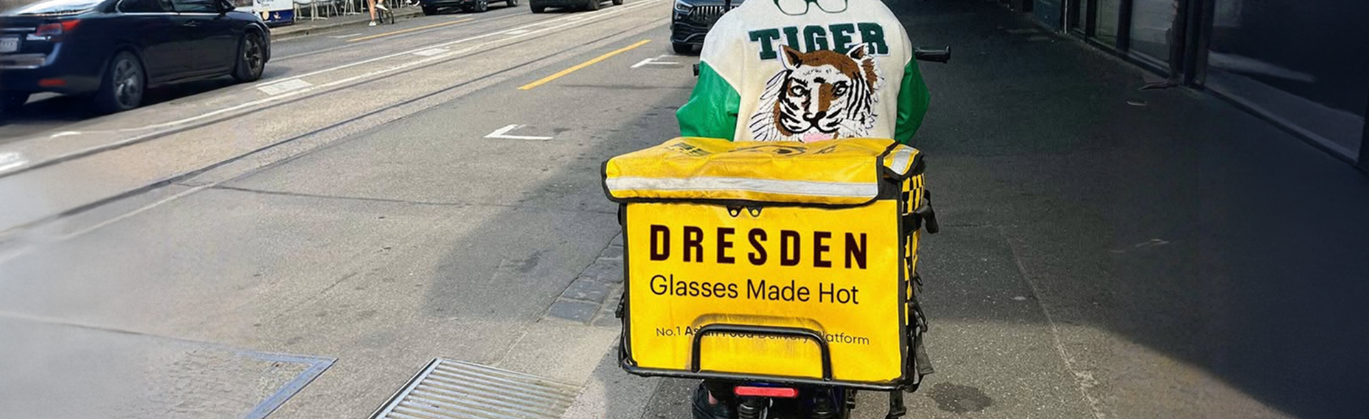 Yellow cart advertising 'Dresden Glasses Made Hot' on a city street, highlighting same-day glasses services.